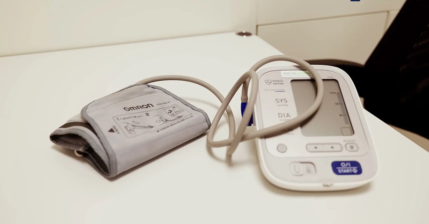 A blood pressure monitor with cuff on the table in the consulting room